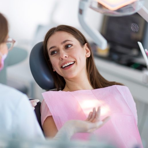 Woman in dental chair talking to her Hammond dentist