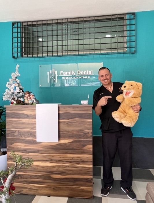 Hammond dentist holding and pointing to a teddy bear with a set of false teeth