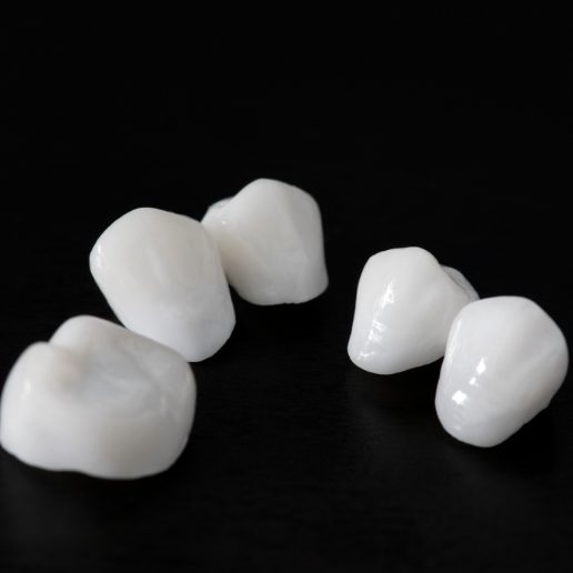 Several dental crowns against a black background