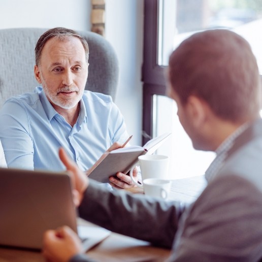 Two businessmen sitting across from each other in coffee shop