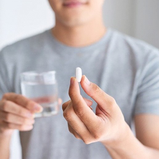a man holding a pill for pain medication