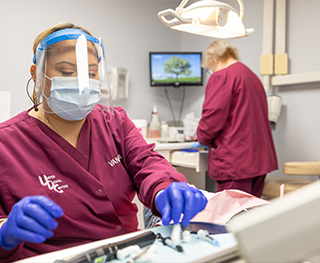 Dental team member selecting a dental instrument from several on a tray