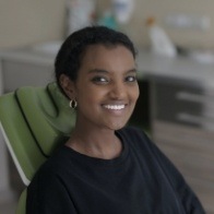 Young woman wearing black shirt smiling in dental chair
