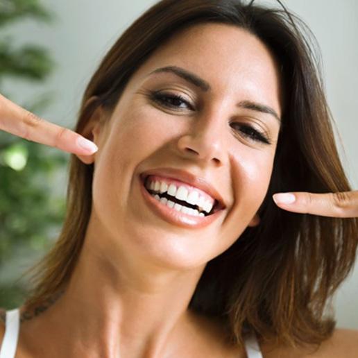 Woman smiling and pointing to her teeth