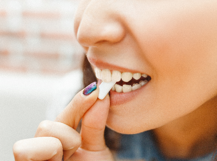 Close up of woman's mouth chewing gum.