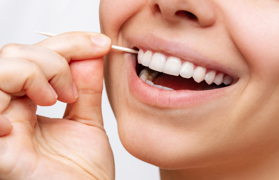 Close up of woman's smile with toothpick